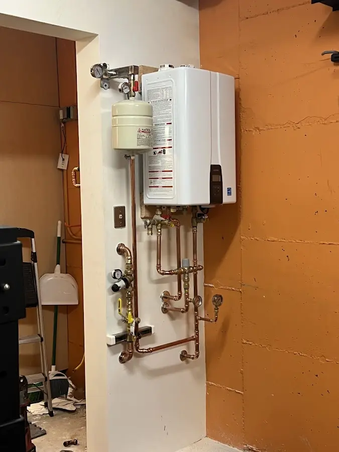 Plumbing technician inspecting water heater connections in Old Saybrook